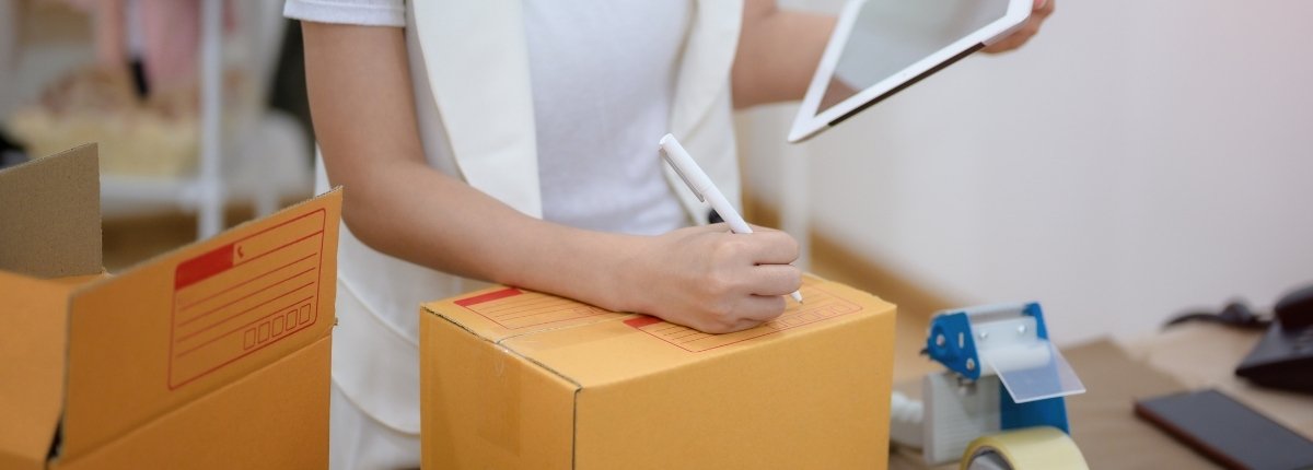 vendeuse devant un carton avec tablette